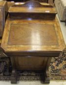 A Victorian walnut and cross-banded Davenport desk, the top with stationery compartment over a