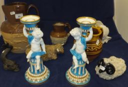 A pair of Minton's porcelain candlesticks in the form of a putti upon a column, a cast metal