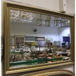 A modern swept gilt framed mirror with b