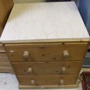 A modern pine chest of three drawers wit