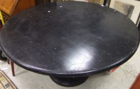 An ebonised circular breakfast table on