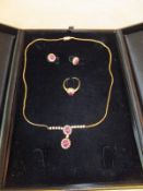 An 18 carat gold diamond and garnet suite of jewellery comprising necklace, earrings and ring