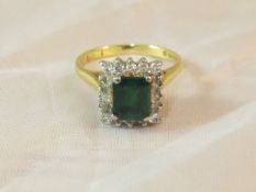 An 18 carat gold, rectangular cut emerald and diamond set dress ring CONDITION REPORTS Emerald has