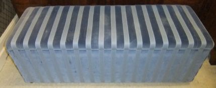 A blue striped upholstered ottoman with
