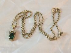 An emerald and diamond pendant on chain