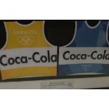 A pair of framed and glazed London 2012 bibs, both inscribed Coca Cola in a framed display,