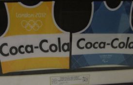 A pair of framed and glazed London 2012 bibs, both inscribed Coca Cola in a framed display,