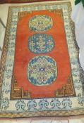 An Oriental rug, the three central medallions in shades of blue, pale green, yellow and salmon,