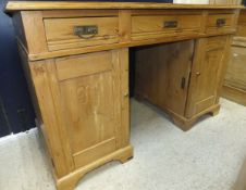 A waxed pine double pedestal desk of three drawers over two cupboard doors on bracket feet