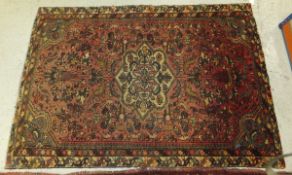 A Persian rug, the centre medallion in madder, salmon,