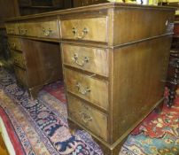 A mahogany pedestal desk of nine drawers with brass handles, on bracket feet,