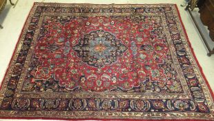 A Persian carpet, the central floral decorated medallion in dark blue, light blue, orange,