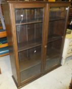 A mahogany display cabinet of two glazed door enclosing shelves