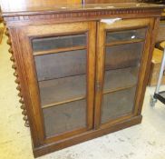 A late Victorian mahogany side cabinet with two glazed doors on a plinth base