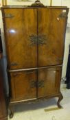 A 20th Century walnut drinks' cabinet in the 18th Century style with two cupboard doors enclosing a