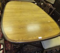 A 1970's Danish teak rounded rectangular extending dining table on end pillar supports united by a