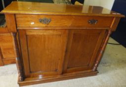 A mahogany chiffonier with single drawer above a pair of cupboard doors flanked by turned and