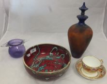 A studio pottery bowl decorated in dark red and turquoise,