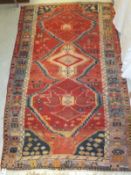 A Caucasian rug, the three central linked medallions in red, cream and blue,