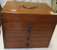 A wooden table top collector's chest of five drawers by Leuchars Limited London