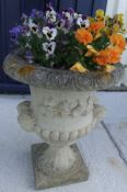 Two composite stone garden planters raised on plinth bases