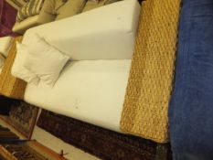 A pair of modern wicker armed conservatory sofas upholstered in cream calico type fabric,