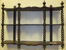 A Victorian oak three tier wall shelf with openwork barley-twist supports