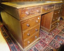 A Victorian pitch pine twin pedestal desk, the top with tooled and gilded leather insert over