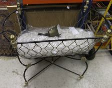 A black painted and gilt decorated wrought iron hanging crib,