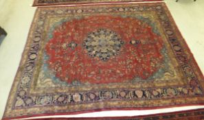 A Persian carpet, the central floral decorated medallion in dark blue, cream and salmon,