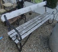 A Victorian garden bench with ironwork frame and white painted wooden seat and back rail