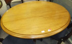 A modern mahogany oval centre table on turned central pedestal to hipped quadruped base