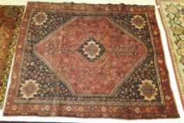 An early 20th Century Persian carpet with red ground centre medallion with floral, bird and animal