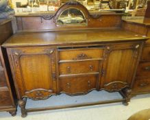 A 1920's oak sideboard in the Gothic Revival taste, the three central drawers flanked by two