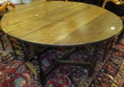 An oak gate-leg drop-leaf dining table with single drawer,