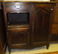 A 20th Century Louis XV style provincial oak cabinet with two cupboard doors and drawer over a
