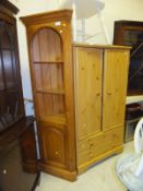 A pine corner unit with open shelves above a cupboard door on plinth base,