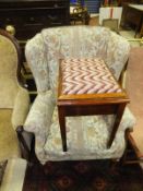 A modern wing back armchair, raised on cabriole front legs,