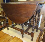 A 1930's oval gate-leg drop-leaf dining table on barley-twist supports