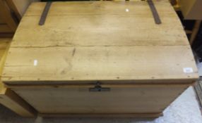 A pine dome top trunk with wrought iron mounts on turned bun feet