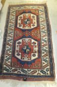 A Turkish rug, the two central medallions in terracotta, cream and blue on a terracotta ground
