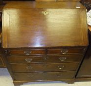 An 18th Century oak bureau, the sloping fall enclosing a stepped fitted interior with various