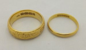 Two 22 carat gold wedding bands, one with engraved scrolling decoration CONDITION REPORTS Bands have