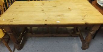 A modern pine rectangular kitchen table on turned and ringed supports united by a centre stretcher