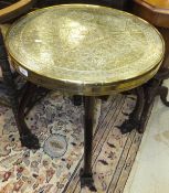 A circa 1900 Chinese padouk wood folding table on dragon mask feet with Benares type brass top