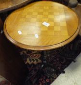 A circular mahogany chequered top occasional table on turned and ringed pedestal to tripod base