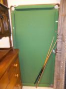 A table top children's billiard table with green baize,