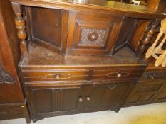 A 1950's oak court cupboard with raised back over two drawers and two cupboard doors,