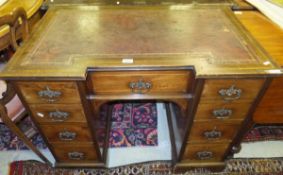 A circa 1900 mahogany and inlaid breakfront desk of small proportions, the tooled and gilded leather