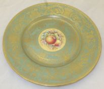 A Royal Worcester cabinet plate painted with fruit by T Nutt on a celadon and gilt decorated ground,